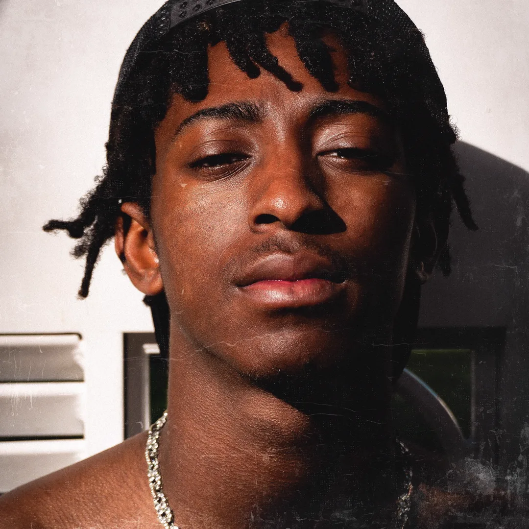 Close-up of HARLEM in a durag under harsh sunlight